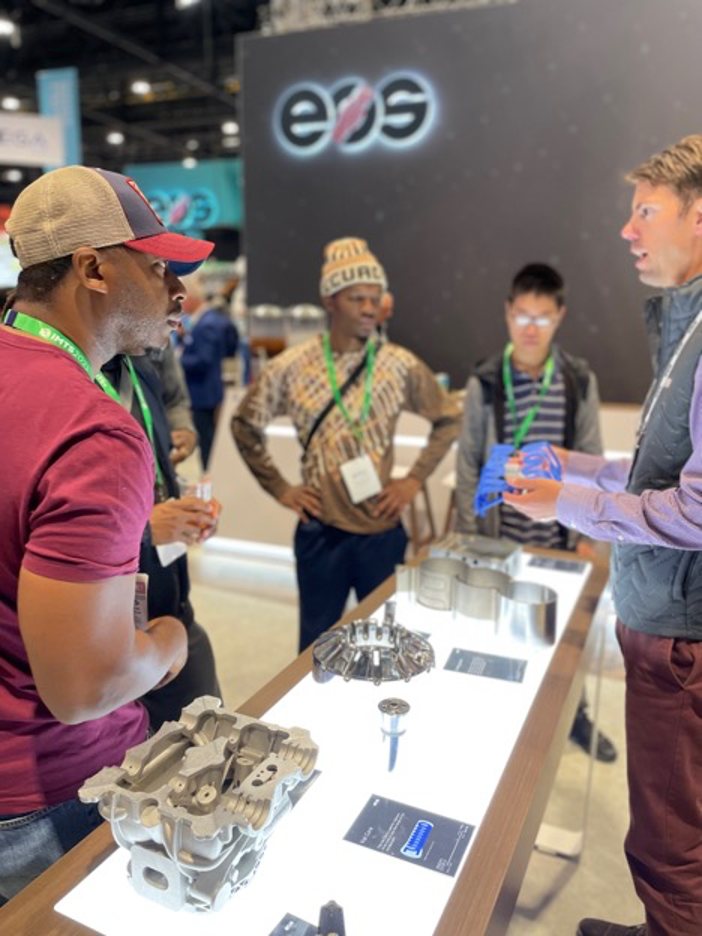 AMx participants discussing manufactured components during an industry visit